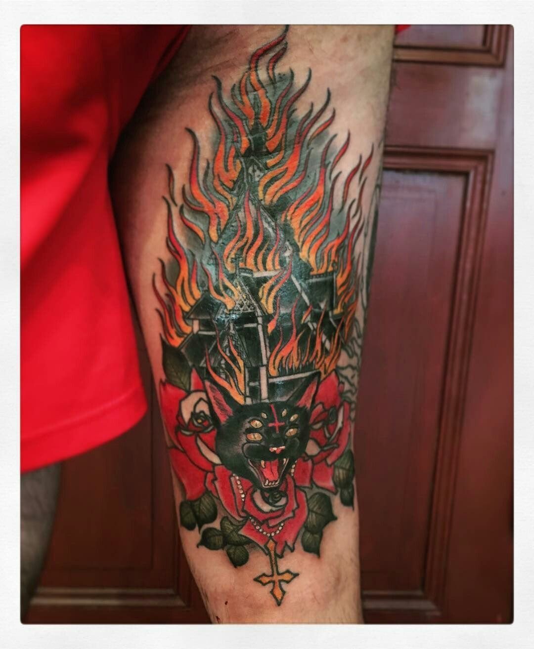 6 Burning Church Tattoo Ideas for Dark, Dramatic Ink 6 A colorful tattoo on a leg depicting a burning church, red roses, and a black cat.