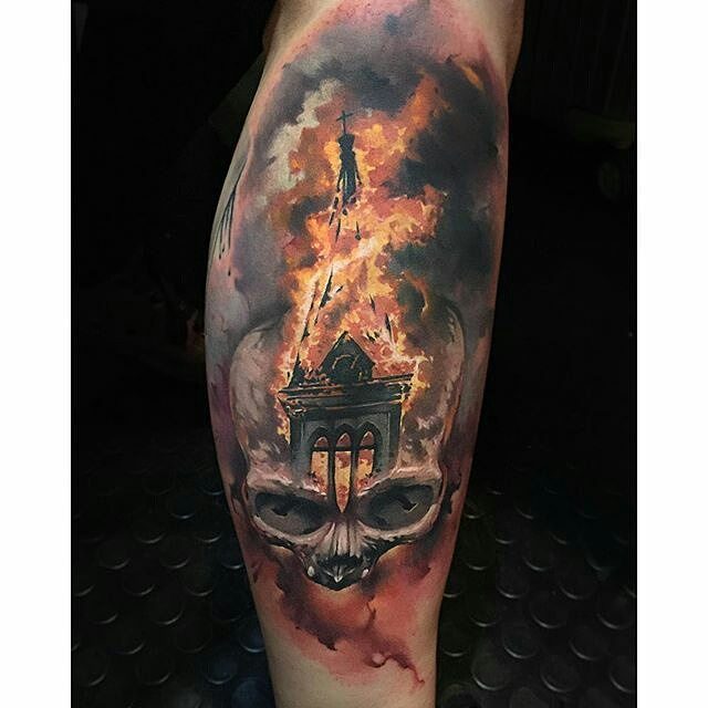 6 Burning Church Tattoo Ideas for Dark, Dramatic Ink 4 A detailed tattoo of a skull with a burning church rising from its head amidst flames.