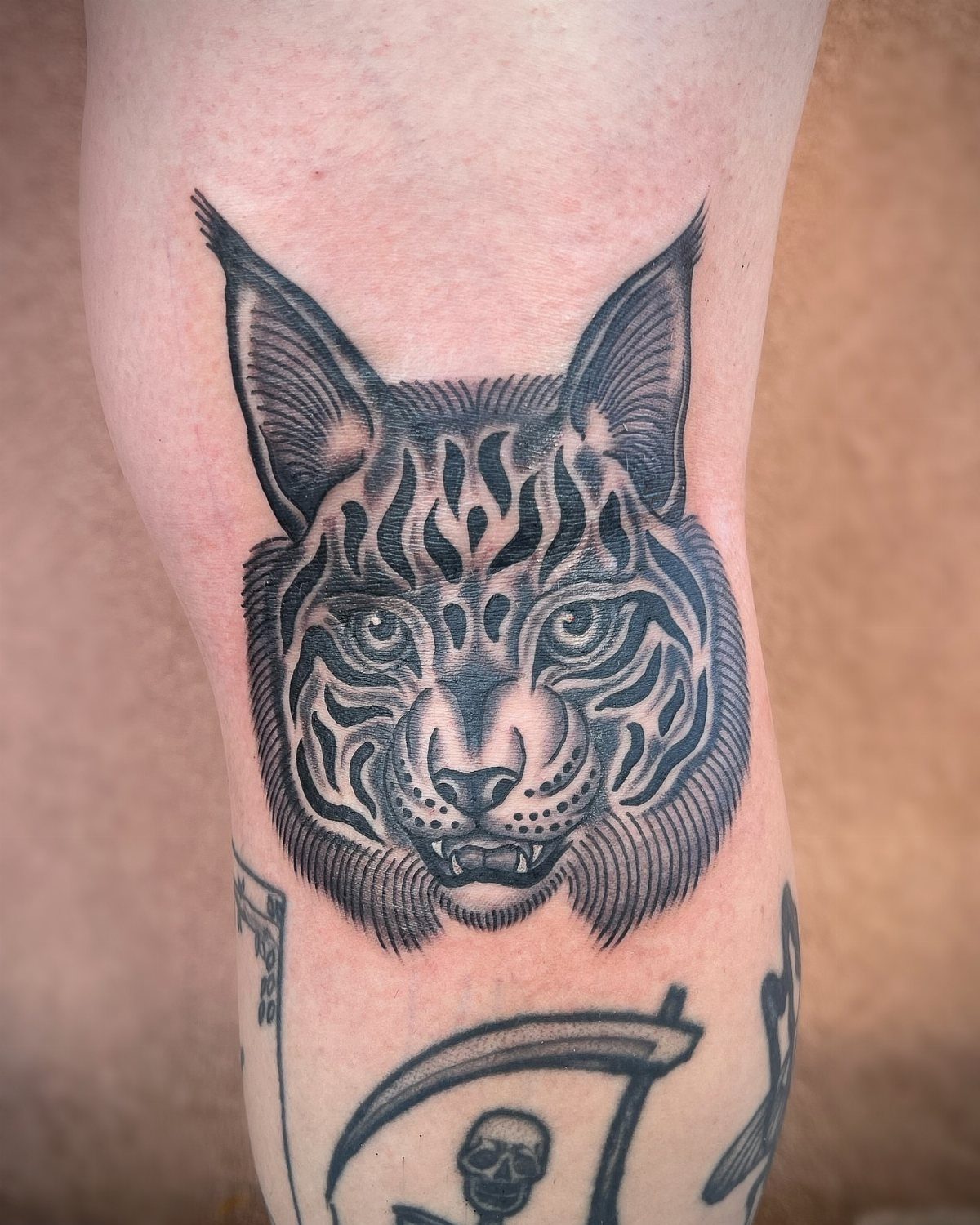 Cat Tattoo with Pattern: 8 Bold Design Ideas to Consider 8 A black ink tattoo of a patterned cat head on a person's leg.