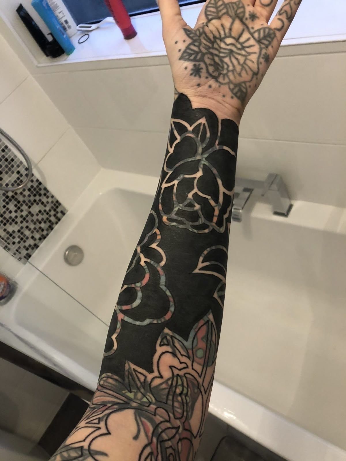 Cover Up Tattoo Pattern: 9 Ways to Hide Old Ink or Scars 4 A person's arm and hand covered in heavy blackwork and floral tattoos.