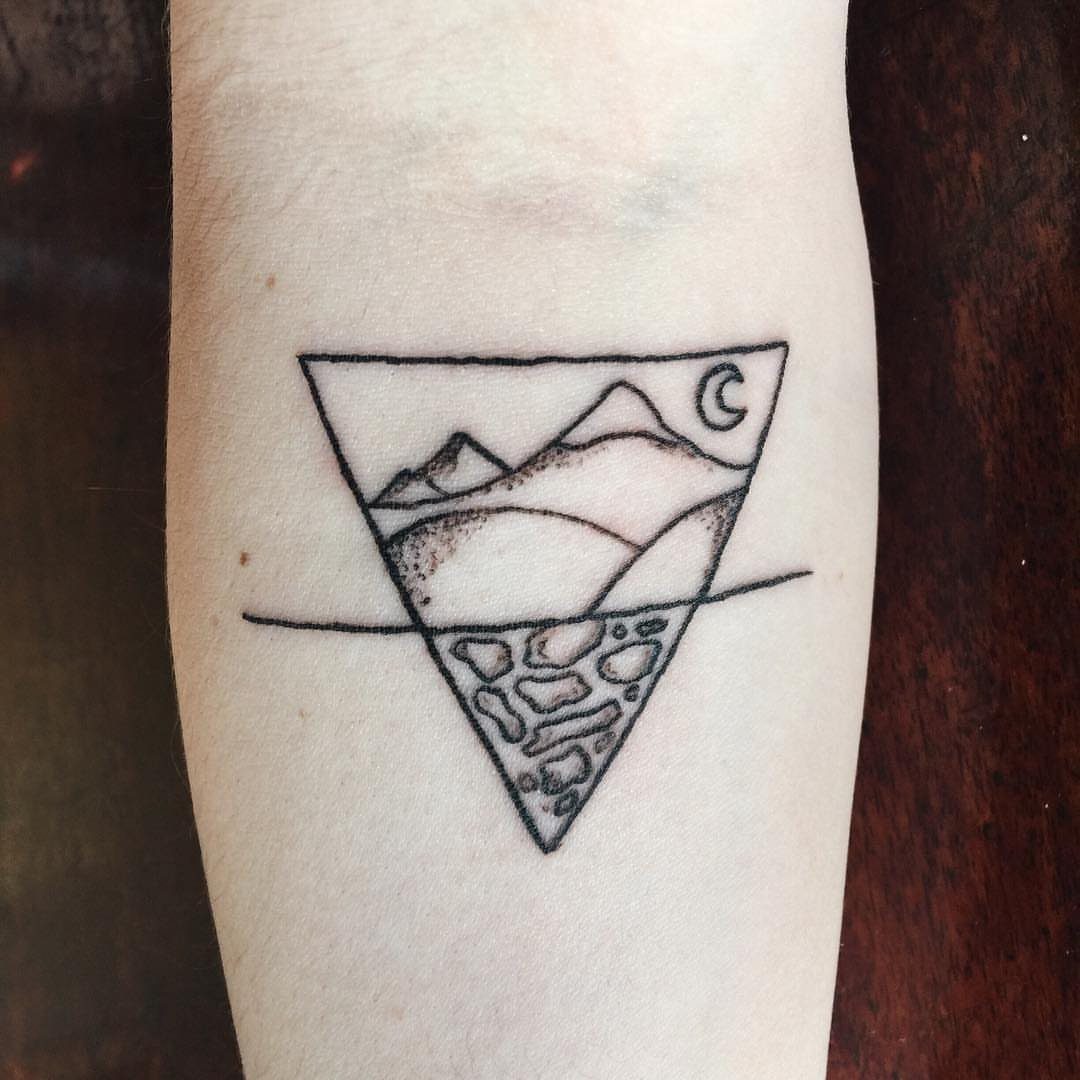 9 Earth Element Tattoo Ideas for Symbols, Scenery and Spirit 2 A minimalist black ink tattoo of a mountain landscape and stones inside an inverted triangle.
