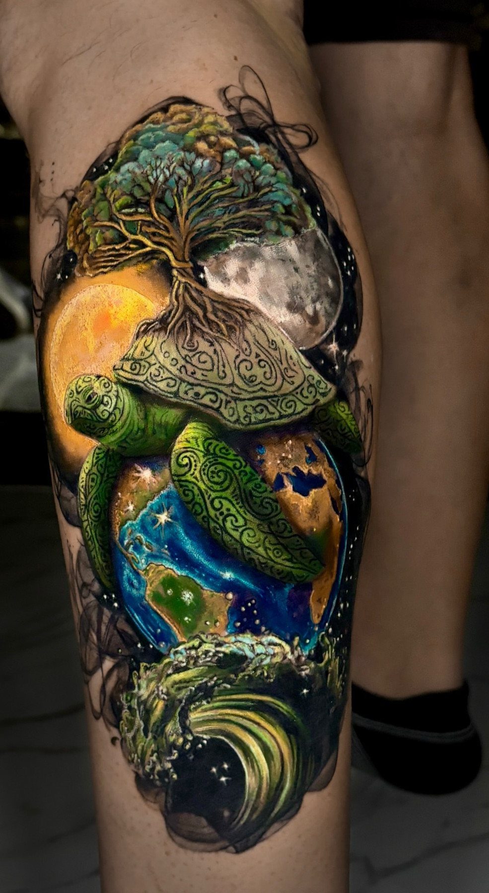 9 Earth Element Tattoo Ideas for Symbols, Scenery and Spirit 3 A detailed colorful tattoo of a turtle carrying a tree and earth on its shell.