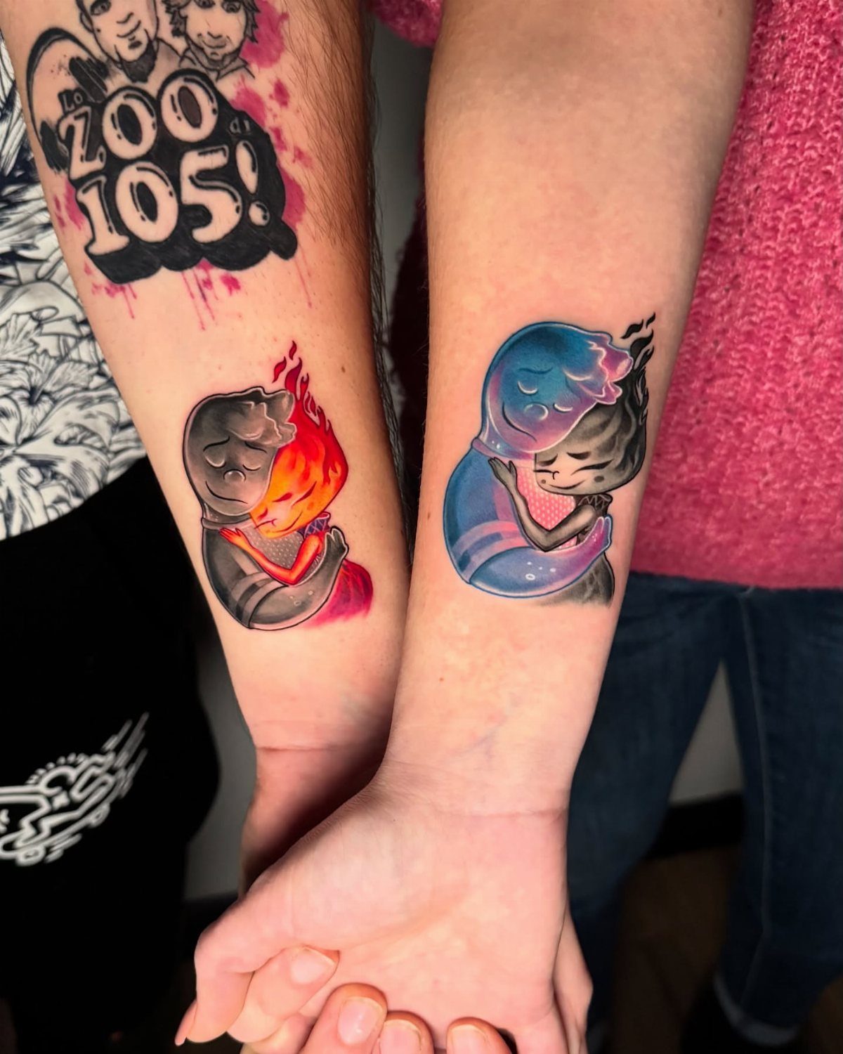 11 Elemental Tattoo Ideas for Your Next Ink 10 Two arms held together displaying elemental tattoos of fire and water figures embracing.
