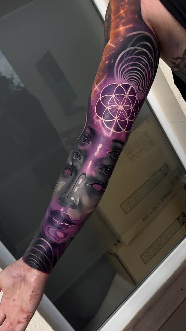 8 Full Arm Tattoo Ideas for Men and Women 8 A person's arm displaying a colorful full sleeve tattoo with cosmic and geometric patterns.