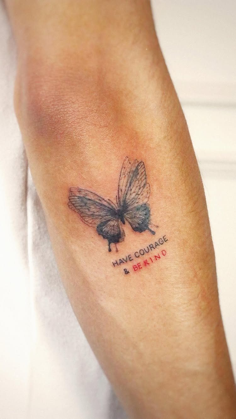 Have Courage and Be Kind Tattoo: 6 Designs Worth Committing To 5 A butterfly tattoo with the text have courage and be kind on a person's arm.