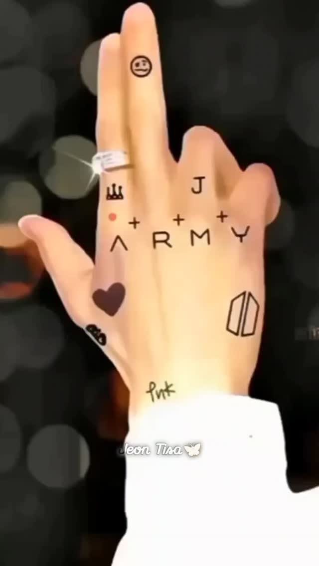 Jungkook Tattoo: 3 Design Ideas From Hands to Full Sleeve 1 A hand featuring several small black tattoos including a heart and the word ARMY.
