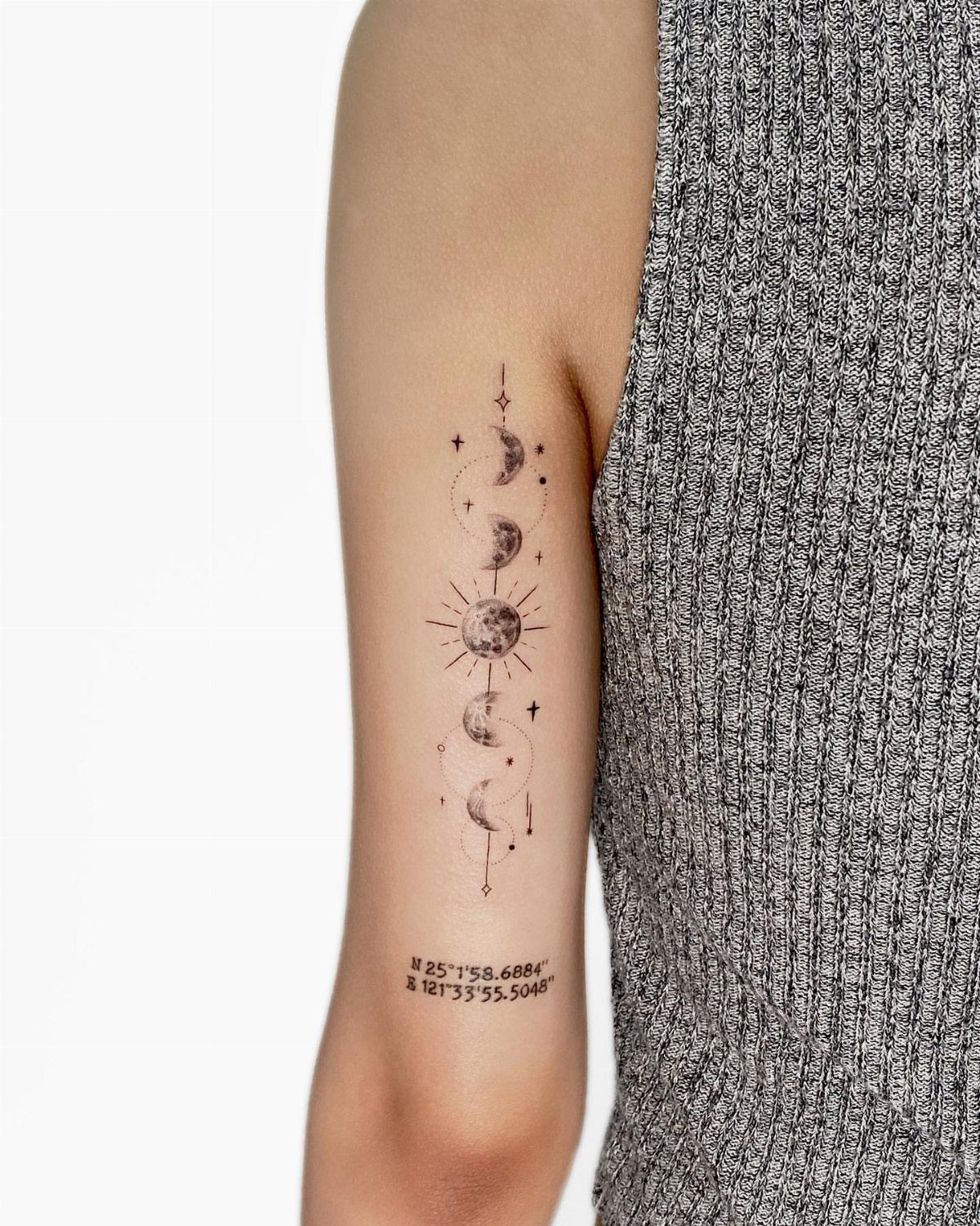 Moon Phases Tattoo Designs for Women: 8 Ideas to Consider 5 Vertical moon phase tattoo with stars and sun rays on a person's upper arm.
