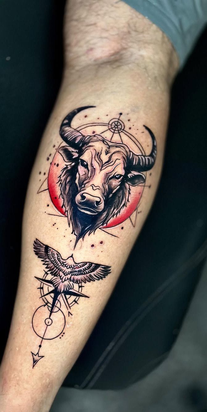 16 Realistic Bull Tattoo Ideas for Strength and Style 2 A detailed bull head tattoo with geometric lines and a red circle on a forearm.