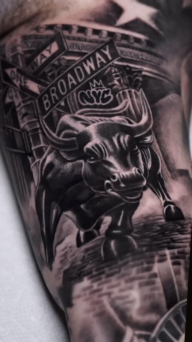 16 Realistic Bull Tattoo Ideas for Strength and Style 16 A detailed black and grey tattoo of a charging bull with Broadway and NYC signage.