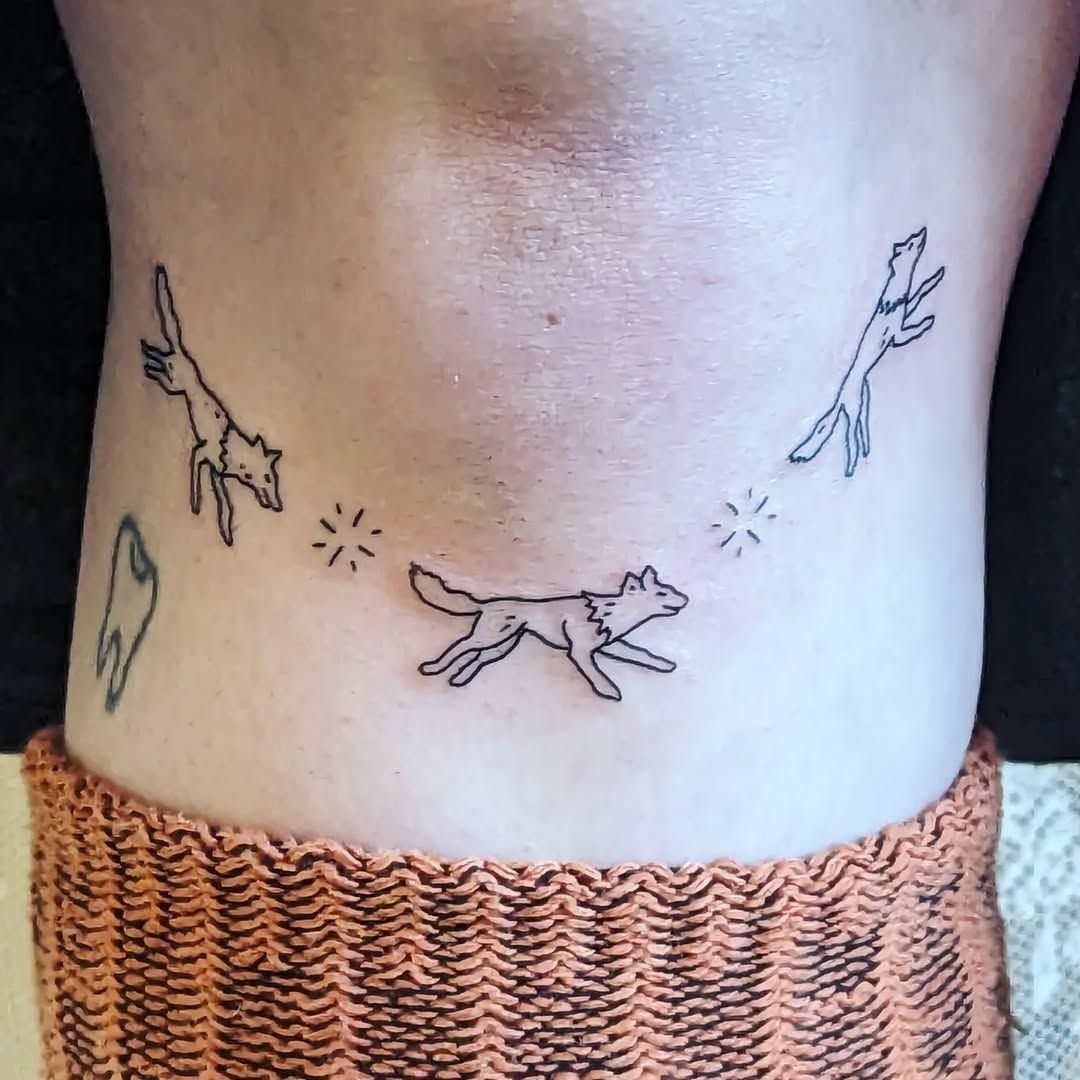 Running Wolf Tattoo: 7 Designs That Move 4 Three small minimalist black ink running wolf tattoos on a person's skin.