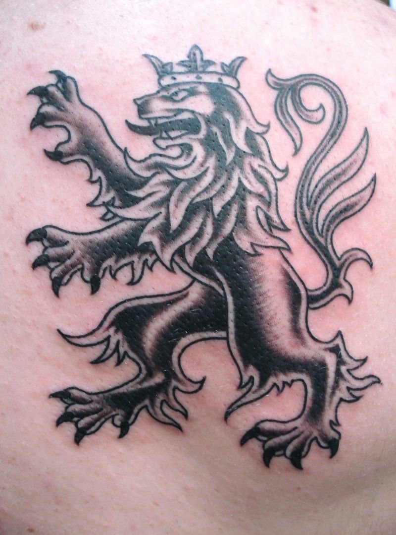 7 Scottish Lion Tattoo Ideas for Your Next Ink 7 A black ink heraldic lion tattoo with a crown on human skin.