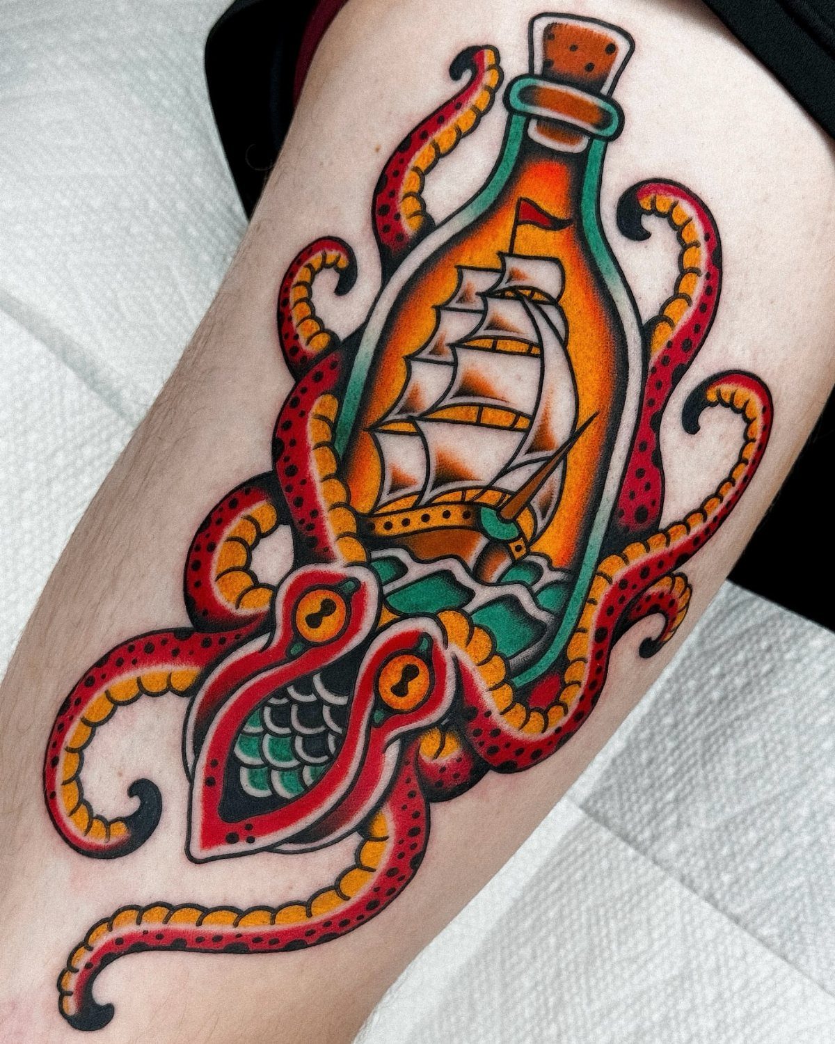 16 Ship Tattoo Ideas in Anchor, Viking, Pirate and Seascape Styles 5 A traditional tattoo of a sailing ship inside a glass bottle being gripped by kraken tentacles.
