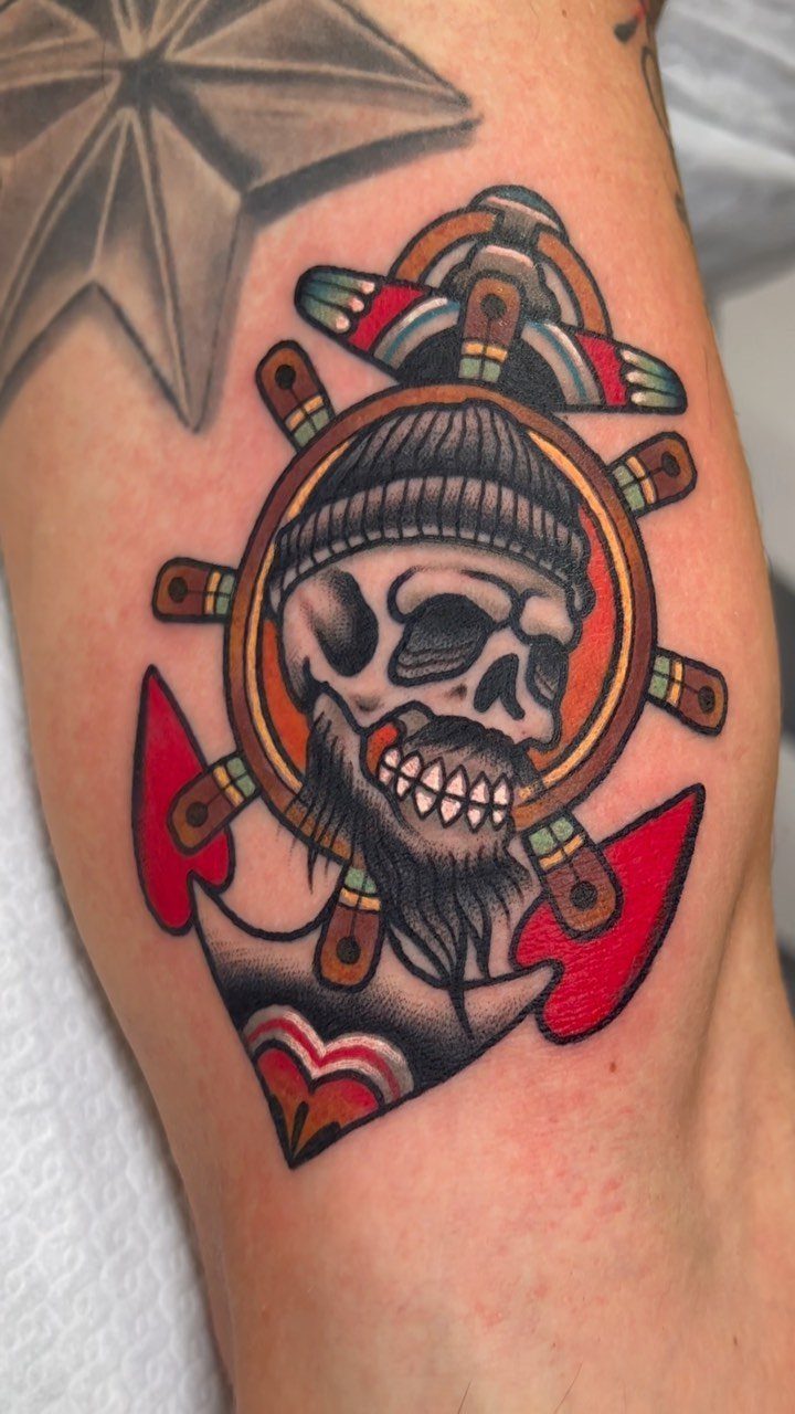 16 Ship Tattoo Ideas in Anchor, Viking, Pirate and Seascape Styles 3 A traditional style tattoo of a skull in a beanie inside a ship wheel and anchor.