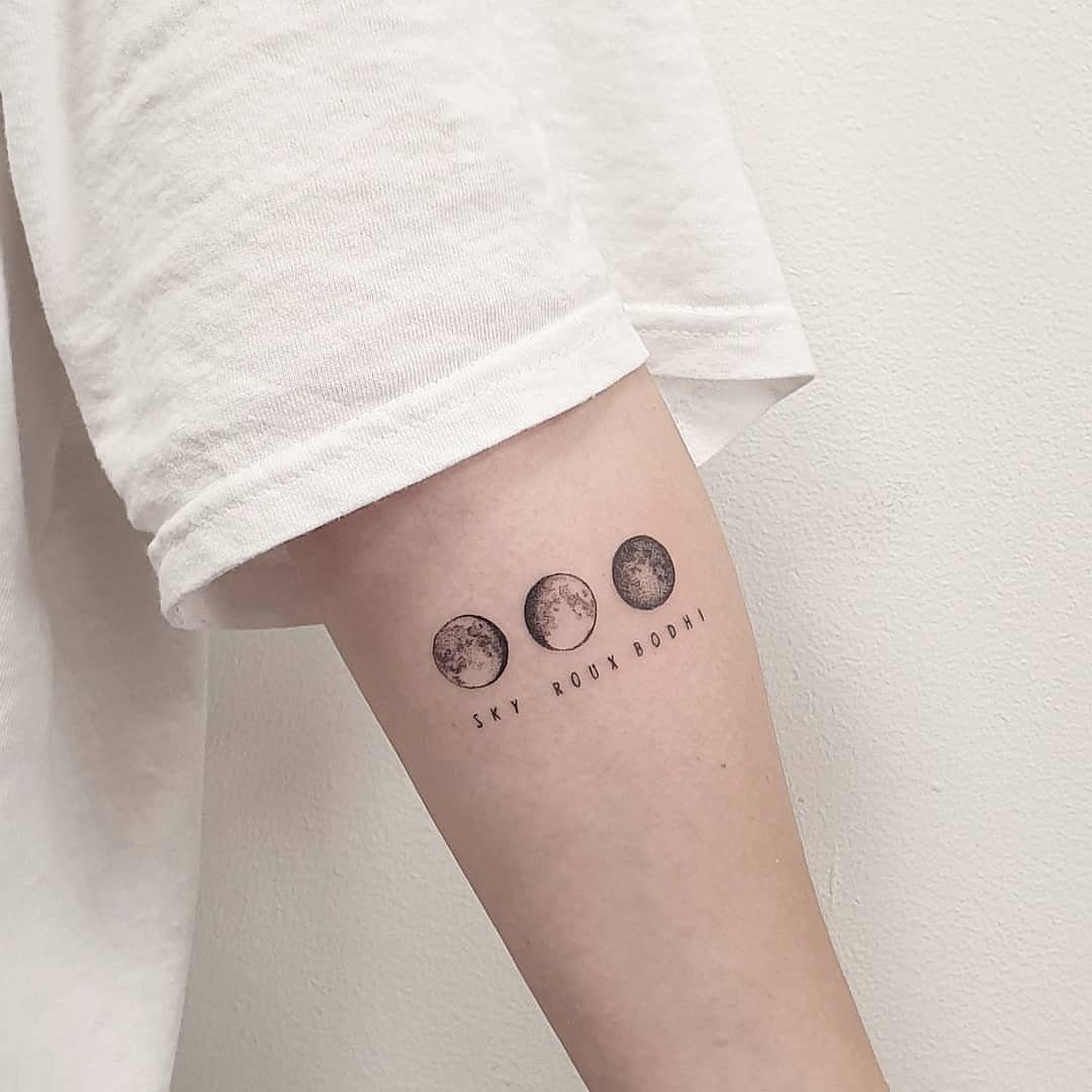 7 Simple Moon Phase Tattoo Designs for Every Style 7 A black ink tattoo of three moon phases on a person's arm.