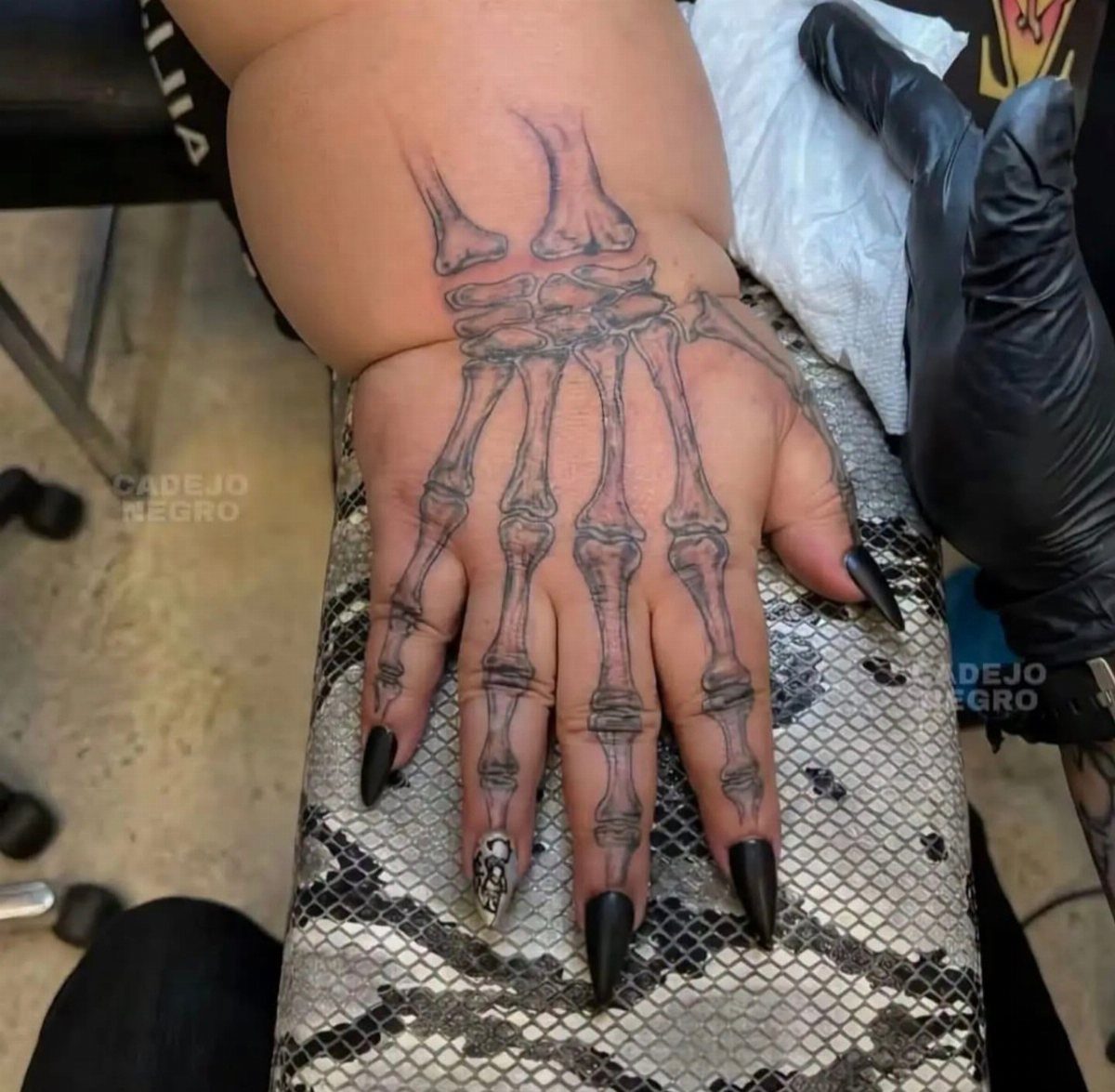 7 Skeleton Hand Tattoo Ideas for Your Next Ink 1 A realistic black and grey tattoo of anatomical hand bones on a person's hand.