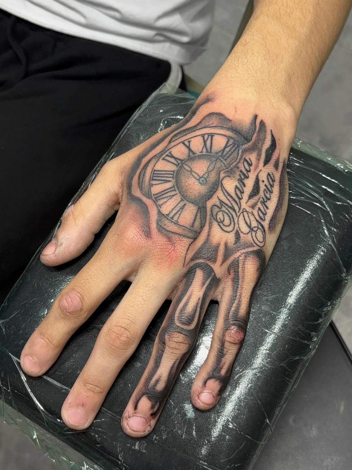 7 Skeleton Hand Tattoo Ideas for Your Next Ink 6 A hand tattoo featuring a skeleton hand combined with a large Roman numeral clock face.