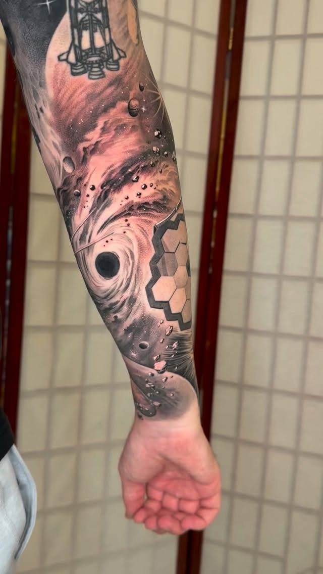 7 Telescope Tattoo Ideas for Every Space and Style 7 A detailed black and grey space-themed tattoo covering a person's entire forearm.