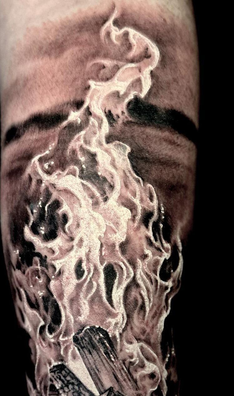 6 Tent Tattoo Ideas for Camping and Circus Styles 2 A detailed black and grey realism tattoo of swirling campfire flames and burning wood logs.