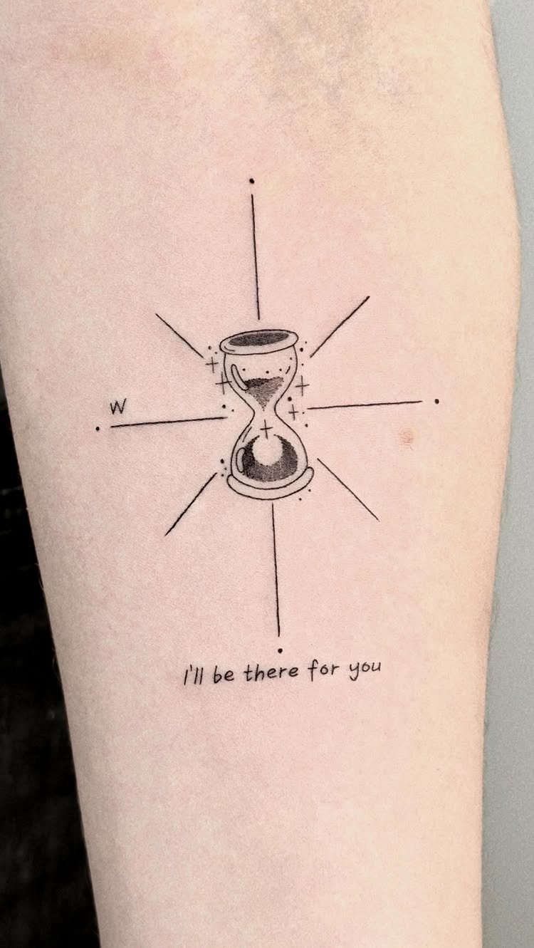 Time Waits for No Man Tattoo: 6 Designs That Mark the Moment 3 A minimalist black ink hourglass tattoo with radiating lines and text on skin.