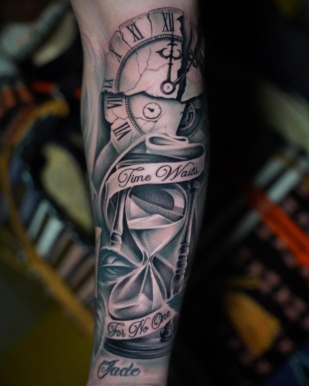 Time Waits for No Man Tattoo: 6 Designs That Mark the Moment 6 A black and grey tattoo on an arm showing a cracked clock and an hourglass.