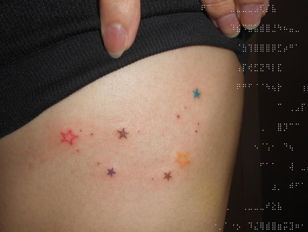 6 Twinkle Star Tattoo Ideas for Light, Sparkly Ink 2 Small colorful star tattoos and tiny dots scattered on a person's skin.