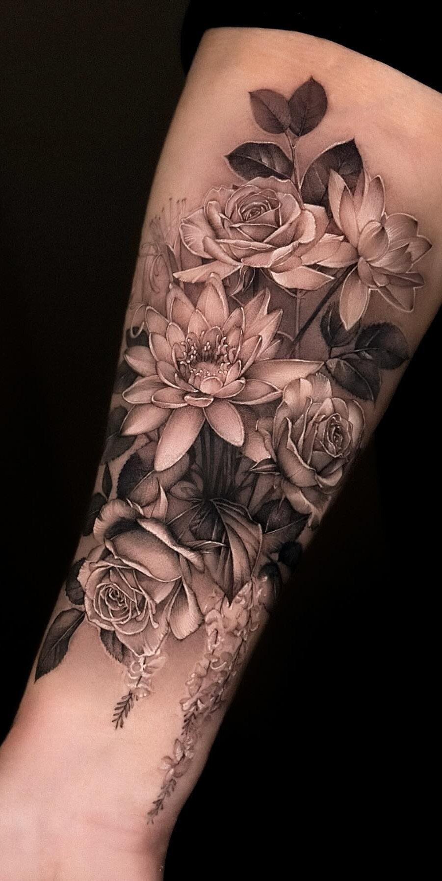 White Ink Water Lily Tattoo: 7 Ideas for Subtle Floral Ink 3 A detailed grayscale tattoo of roses and water lilies on a person's forearm.